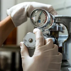 Close-up of a hand adjusting a gas pressure regulator