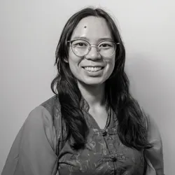 asian woman in a malaysian-chinese batik shirt with glasses, smiling