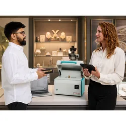 SPECTROSCOUT kt Portable ED-XRF Precious Metals Analyzer on table with 2 people in framing the machine