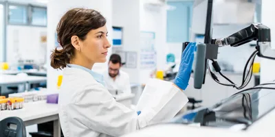 Scientist reviewing data at a computer in a genomics laboratory.