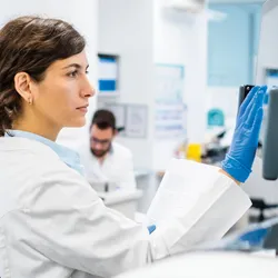 Scientist reviewing data at a computer in a genomics laboratory.