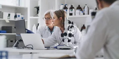 Two scientists collaborate on lab data analysis.