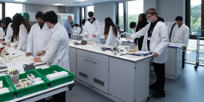 Large group of researchers working at stations in a modern lab.