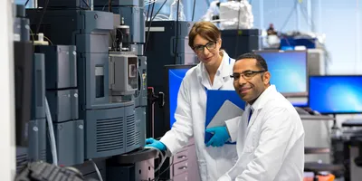 Two scientists working with a mass spectrometer