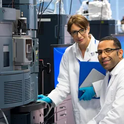 Two scientists working with a mass spectrometer