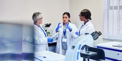Three lab professionals discussing a project in the lab