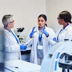 Three lab professionals discussing a project in the lab