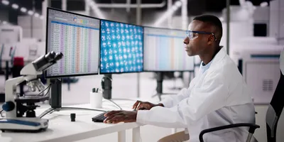 African American male scientist reviewing spreadsheet on computer in the lab.