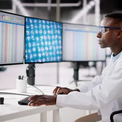 African American male scientist reviewing spreadsheet on computer in the lab.