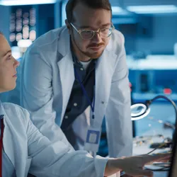 Two scientists analyzing data on a lab computer.