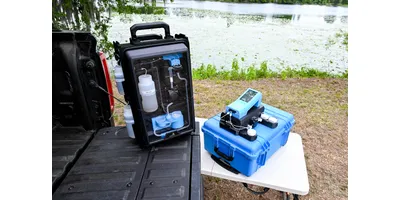 The modular, rapid PFAS screening system rests on a vehicle tailgate and a small table outdoors near a lake.