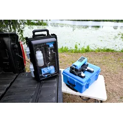 The modular, rapid PFAS screening system rests on a vehicle tailgate and a small table outdoors near a lake.