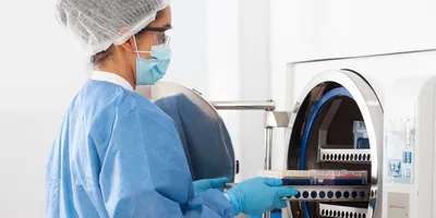 Laboratory worker operating autoclave equipment safely