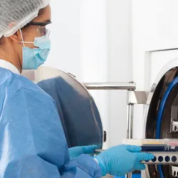 Laboratory worker operating autoclave equipment safely
