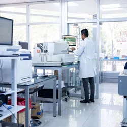 African American scientist working in laboratory filled with high-end instruments