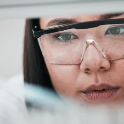 Close-up of a scientist handling drug compounds in a laboratory.