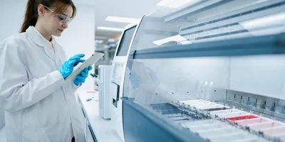 Laboratory professional using a tablet in a clinical lab.