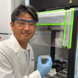 Researcher holding organ-on-chip device for toxicity testing