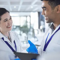 Two lab staff smiling in the lab, representing a strong safety culture.