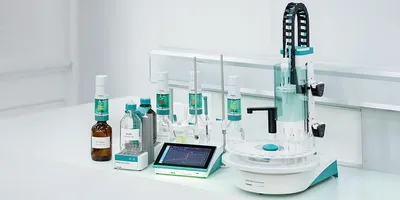 The Metrohm IONIC Titrator on a lab bench: touchscreen control unit showing a live titration curve, with burette stand, dosing unit, and reagent bottles.