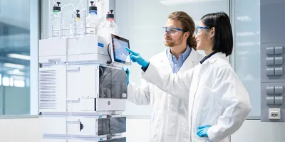 Image of lab workers operating an Infinity HPLC system