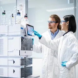 Image of lab workers operating an Infinity HPLC system